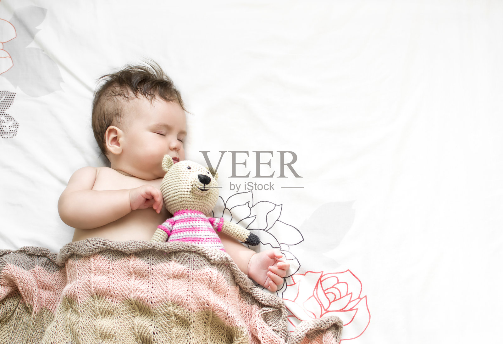 那孩子抱着泰迪熊睡在床上照片摄影图片