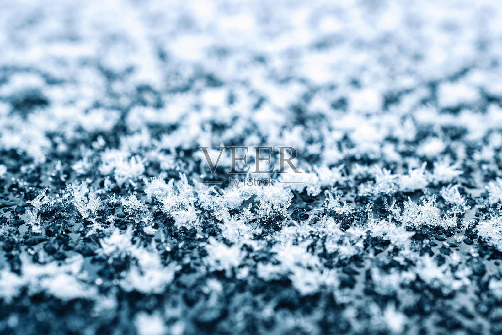 结霜宏。寒冷的冬季雪背景。蓝色水晶冻结抽象图案。白霜冰质。照片摄影图片