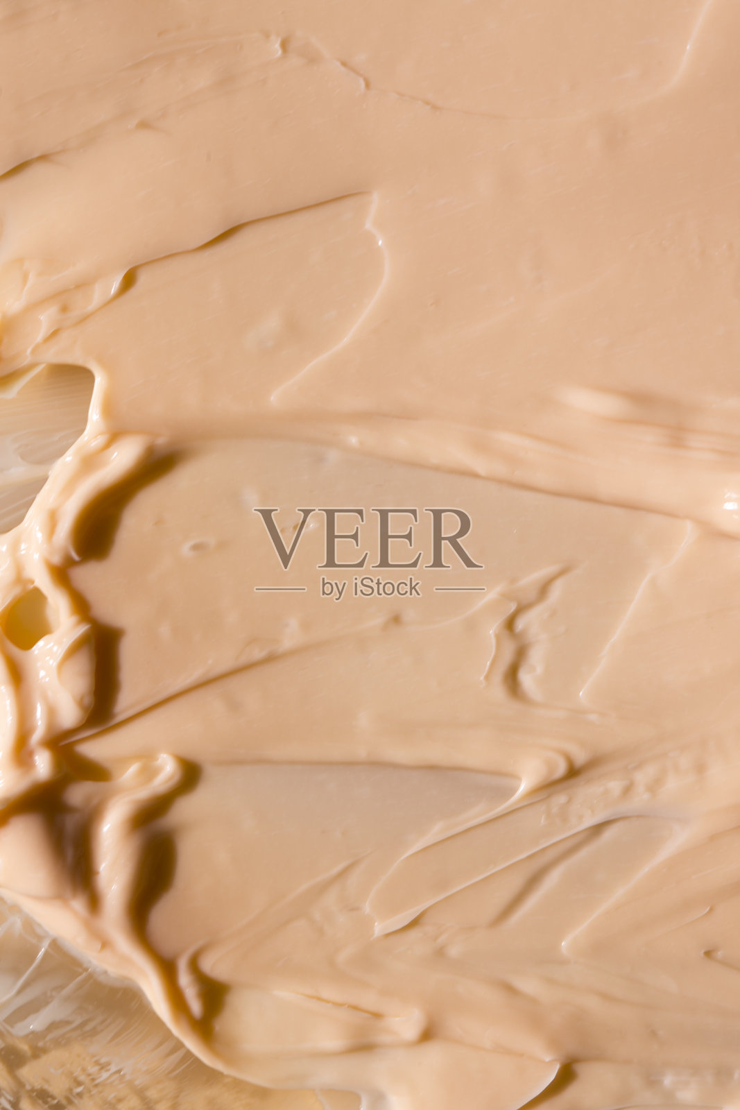 美容精华啫哩质感。粉红色透明的泡沫背景护肤霜。透明彩妆产品接近照片摄影图片