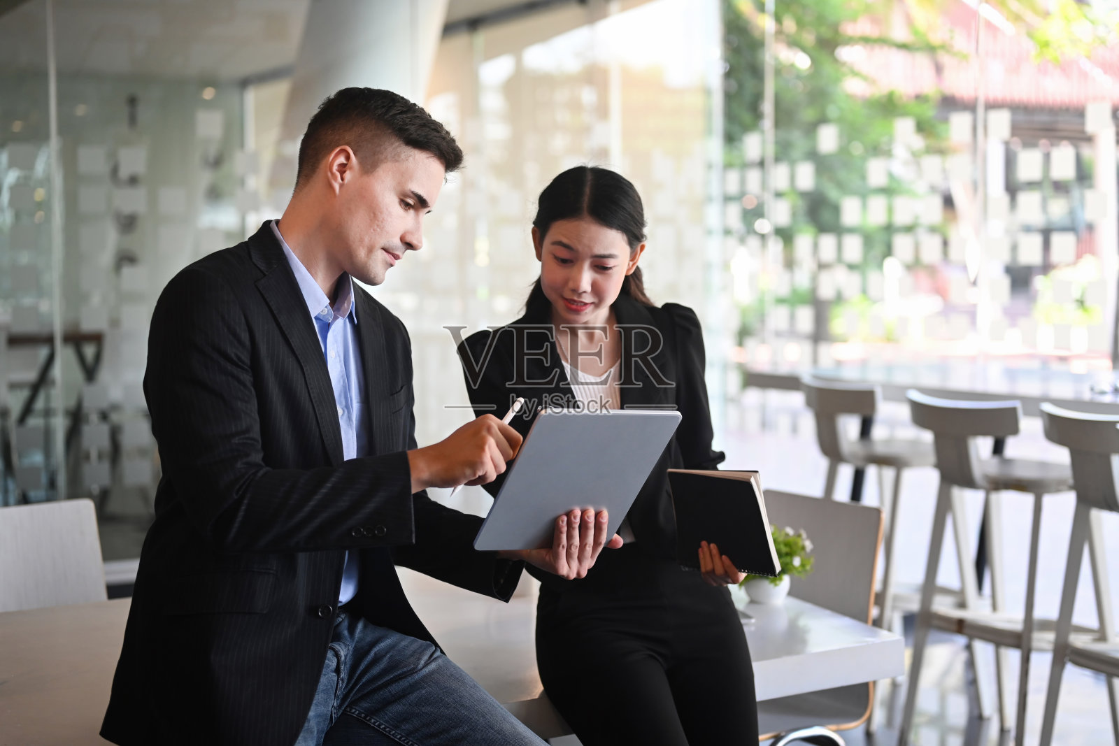 两个业务同事在办公室讨论新的创业项目。照片摄影图片