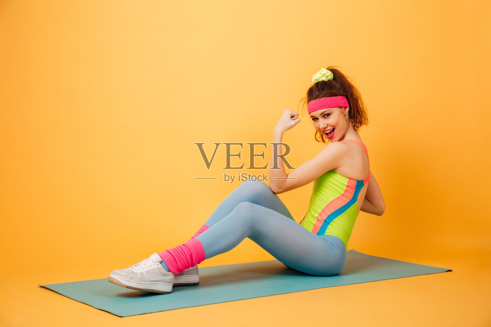 微笑的年轻女运动员在垫子上锻炼腹部肌肉照片摄影图片