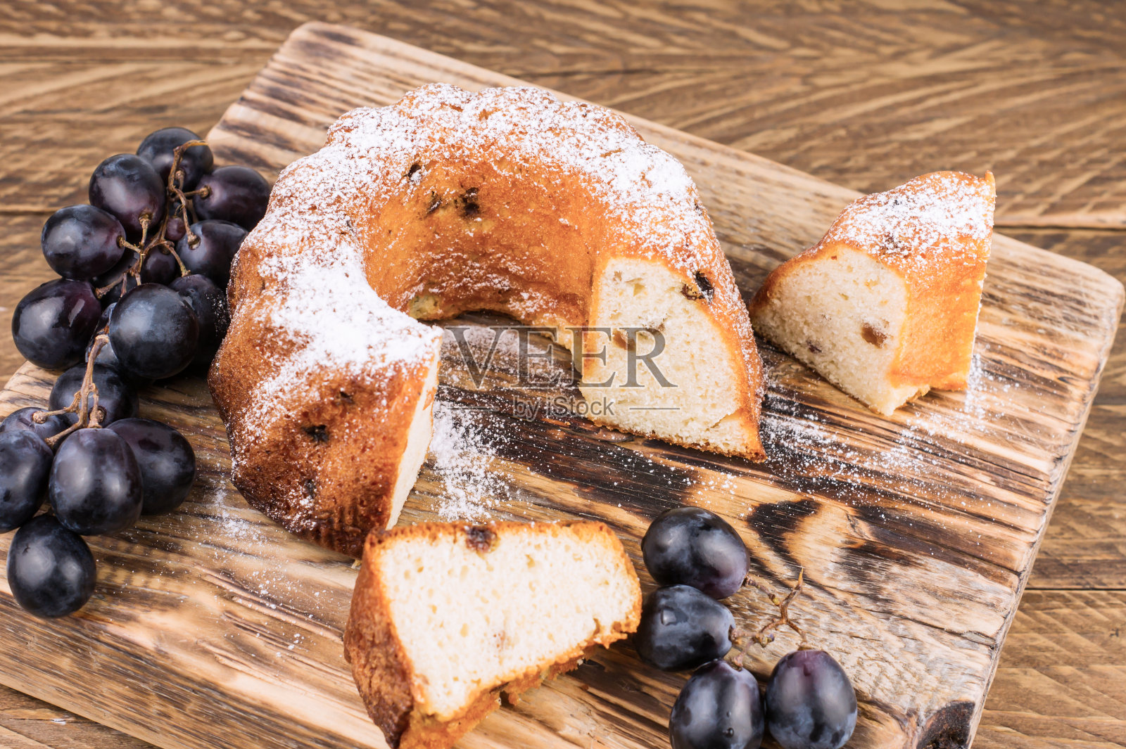 俯视图切片纸杯蛋糕与葡萄干在木板和乡村桌子。自制的蛋糕。照片摄影图片