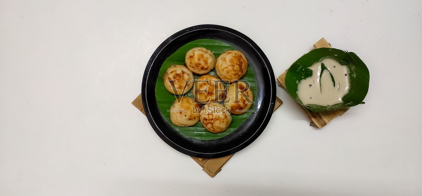 南印度传统菜肴Kuzhipaniyaram的特写与椰子酸辣酱孤立照片摄影图片