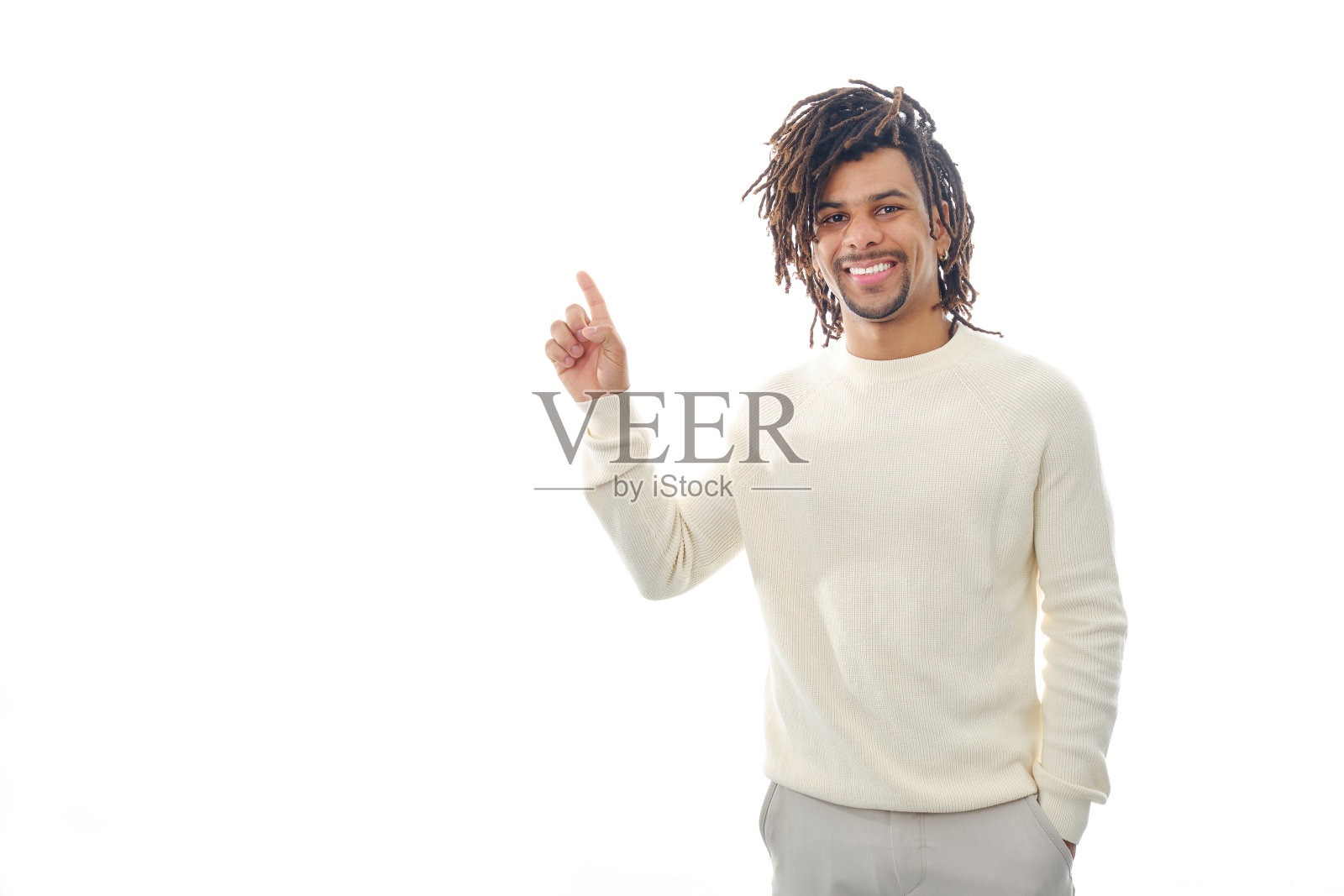 一个快乐的拉丁人站在一个孤立的背景上，用手指着展示着什么。照片摄影图片