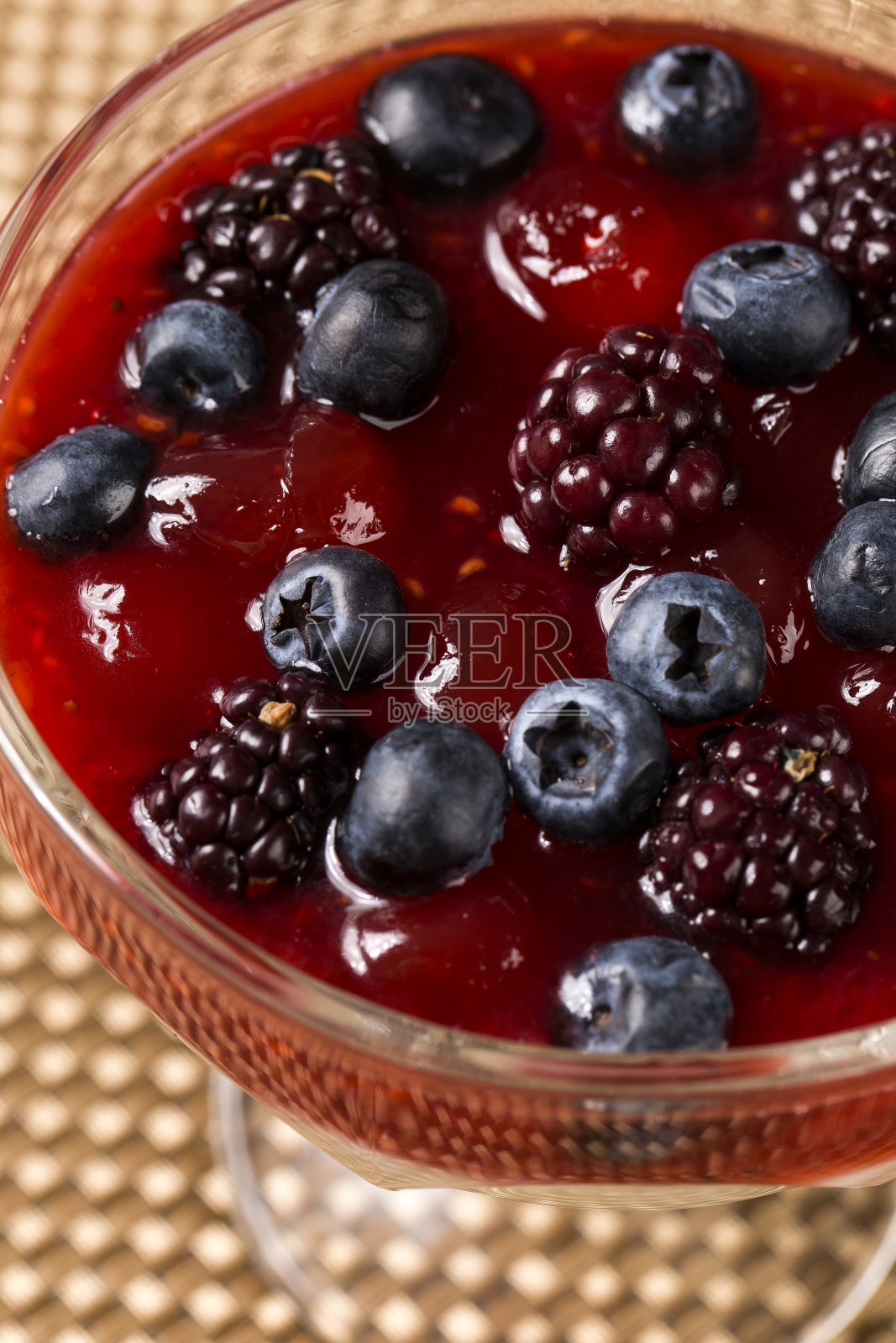披着覆盆子酱汁的Pannacota甜点，新鲜的覆盆子和几片新鲜的薄荷叶照片摄影图片