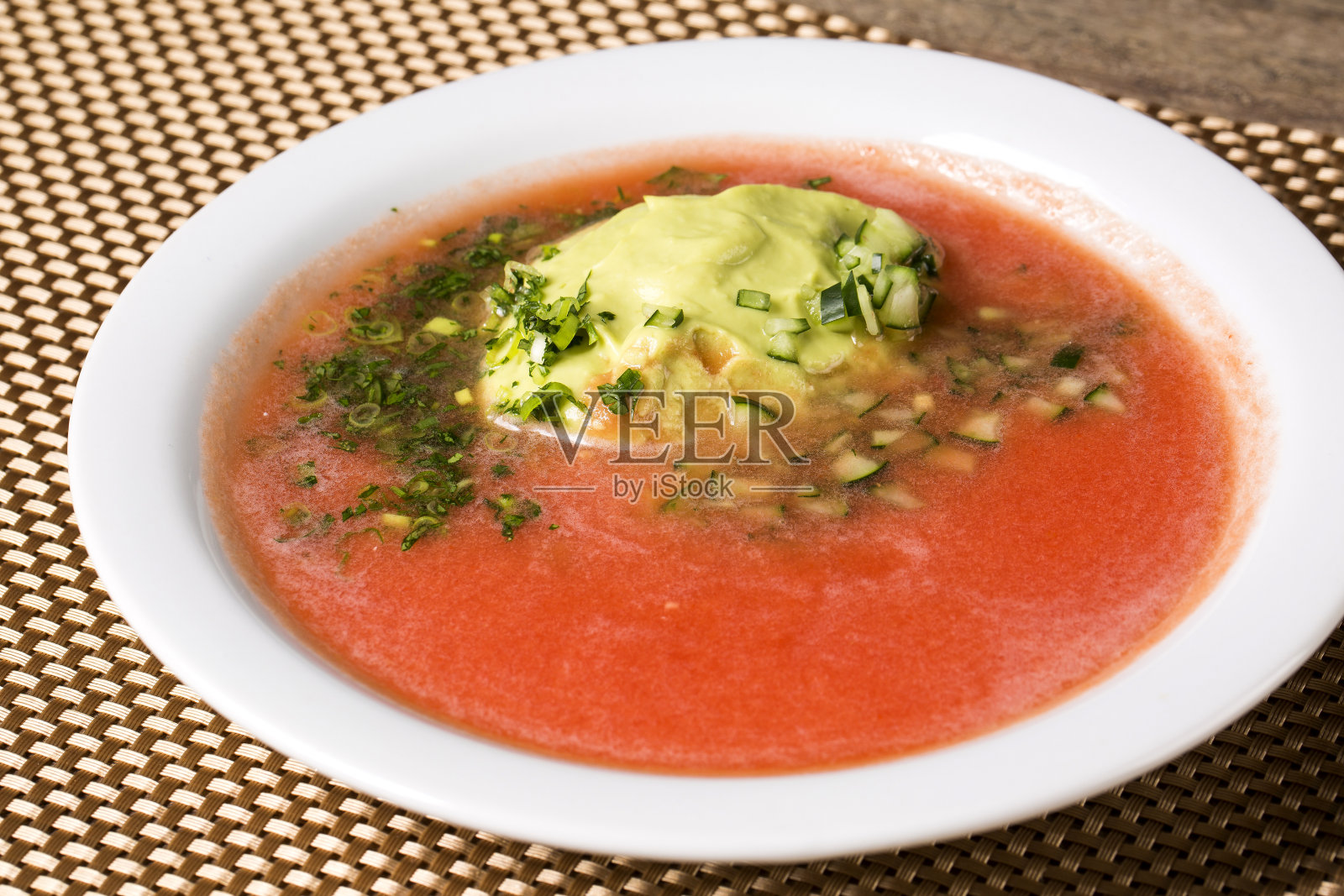 新鲜番茄汤在一个白色碗与鳄梨照片摄影图片