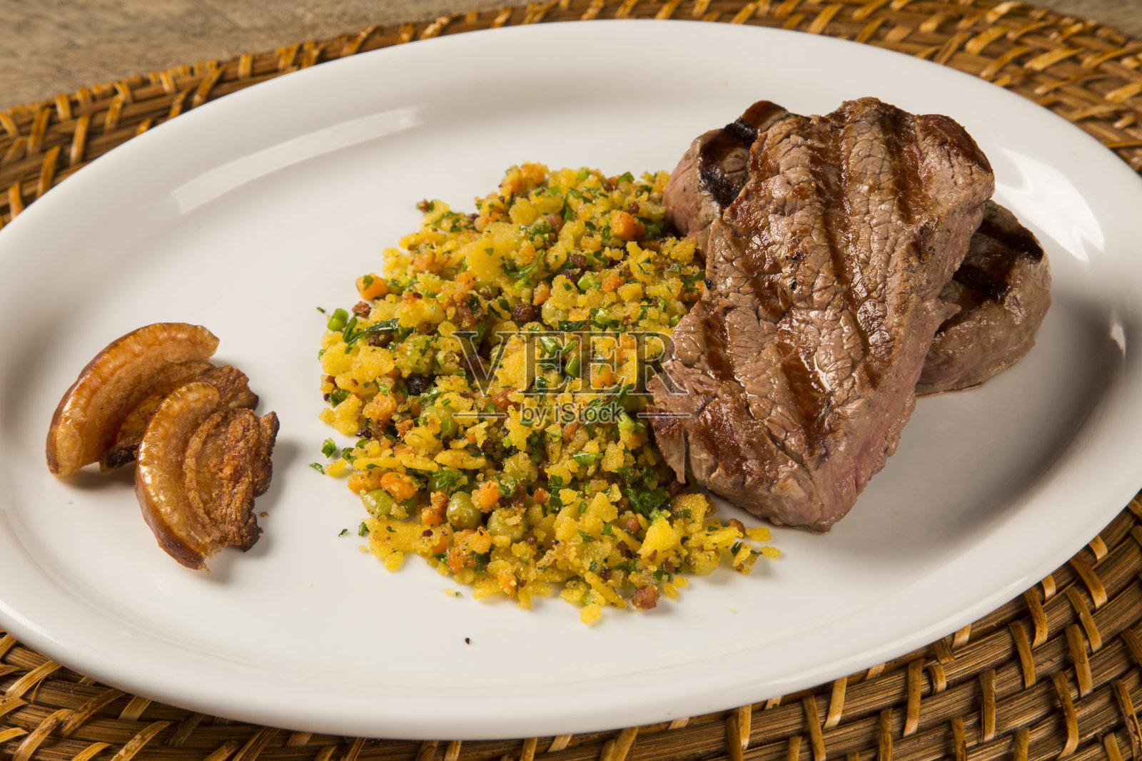 菲力牛排与面包屑和培根烤盘照片摄影图片