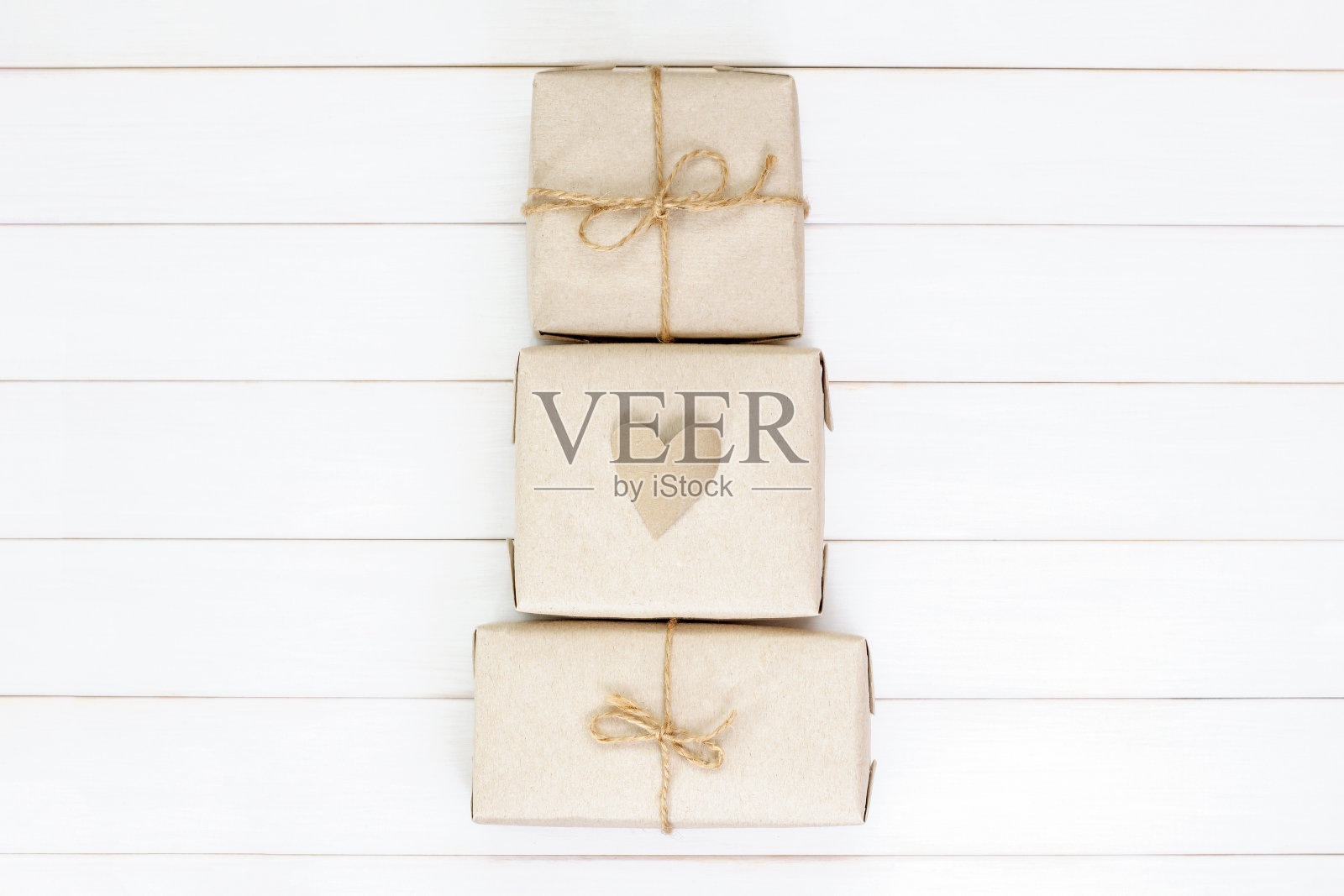 圣诞树由白色木制背景上的礼物盒制成。平的。新年假期概念。照片摄影图片