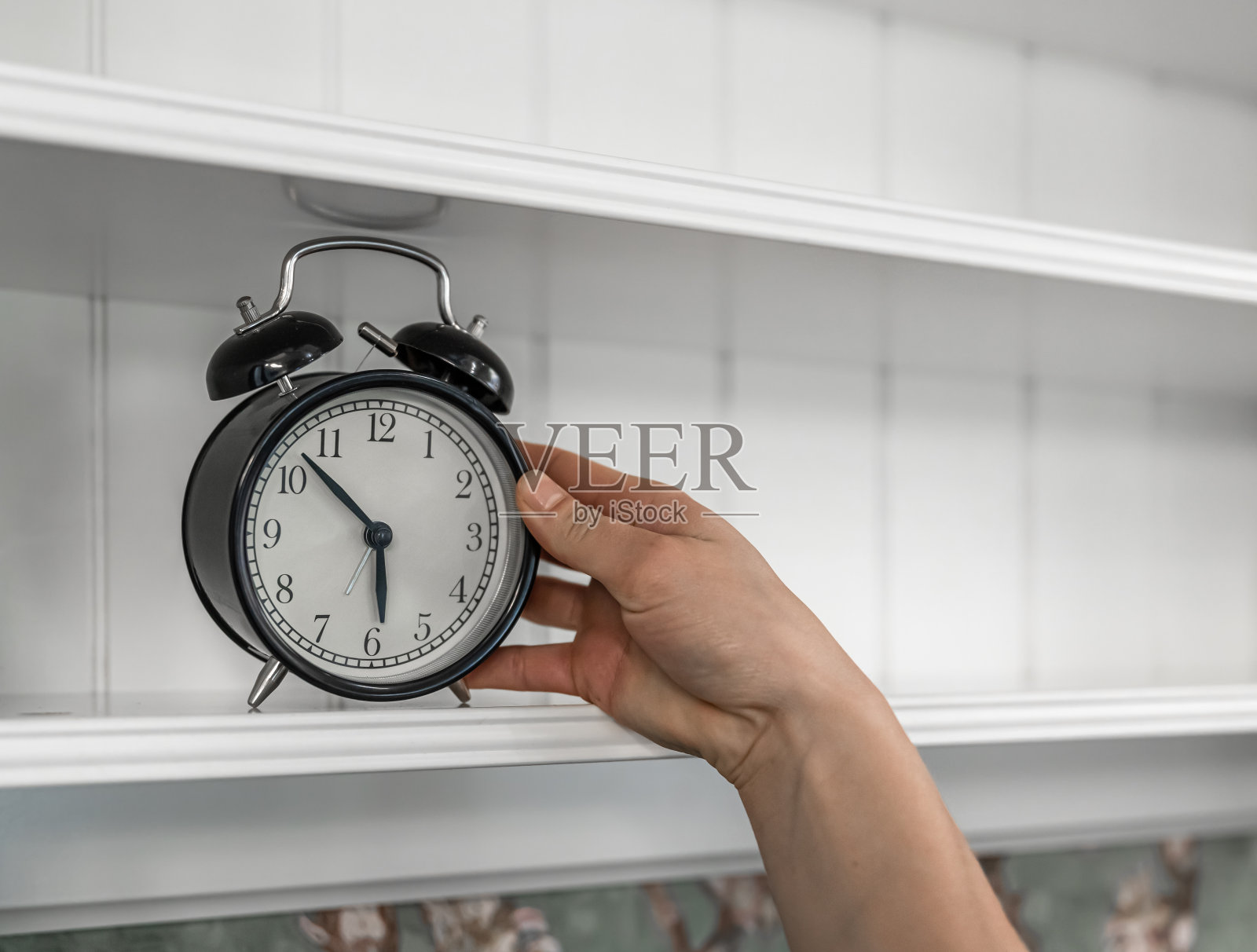 经典的老式闹钟放在房间内部的架子上。照片摄影图片