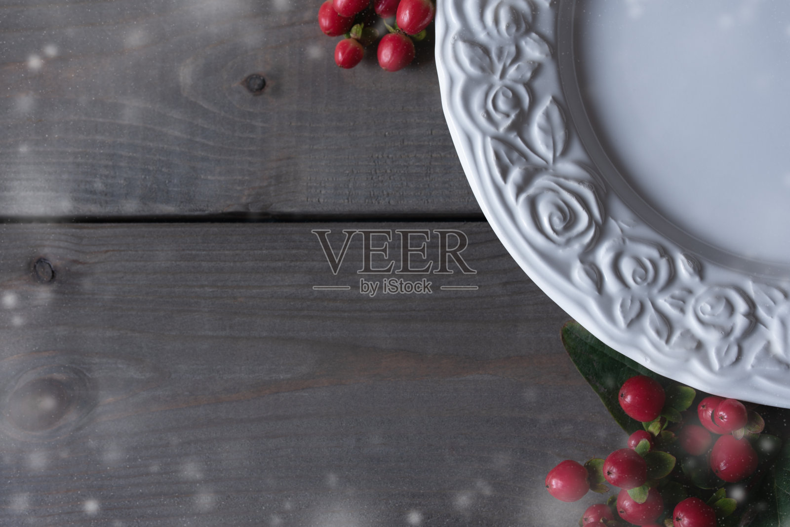 平面视图的一个白色盘子甜的冬季甜点装饰雪花框和红色浆果。照片摄影图片