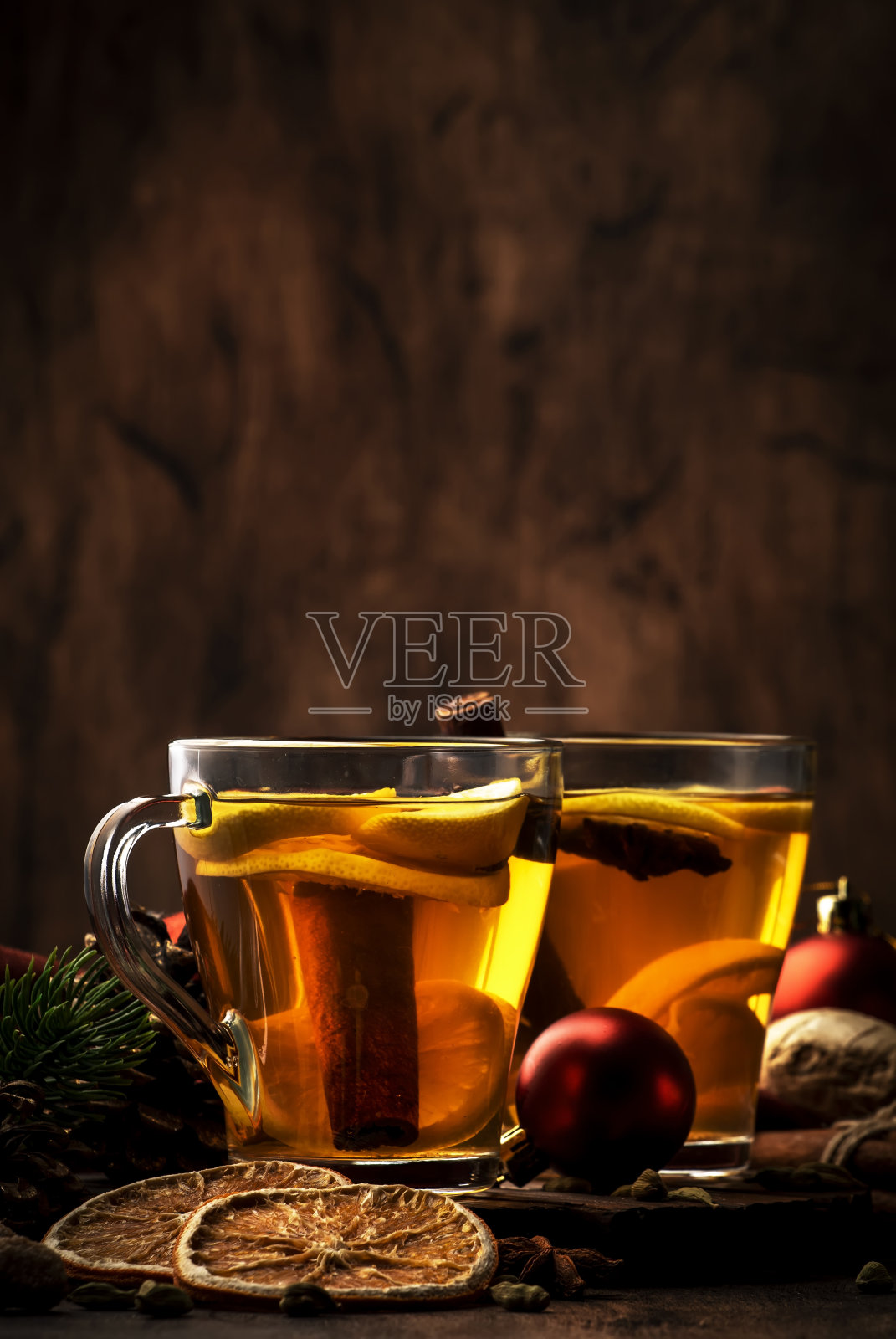 冬季热疗茶与姜，蜂蜜，柠檬和香料在玻璃杯与蒸汽，乡村木制背景。圣诞节表设置照片摄影图片