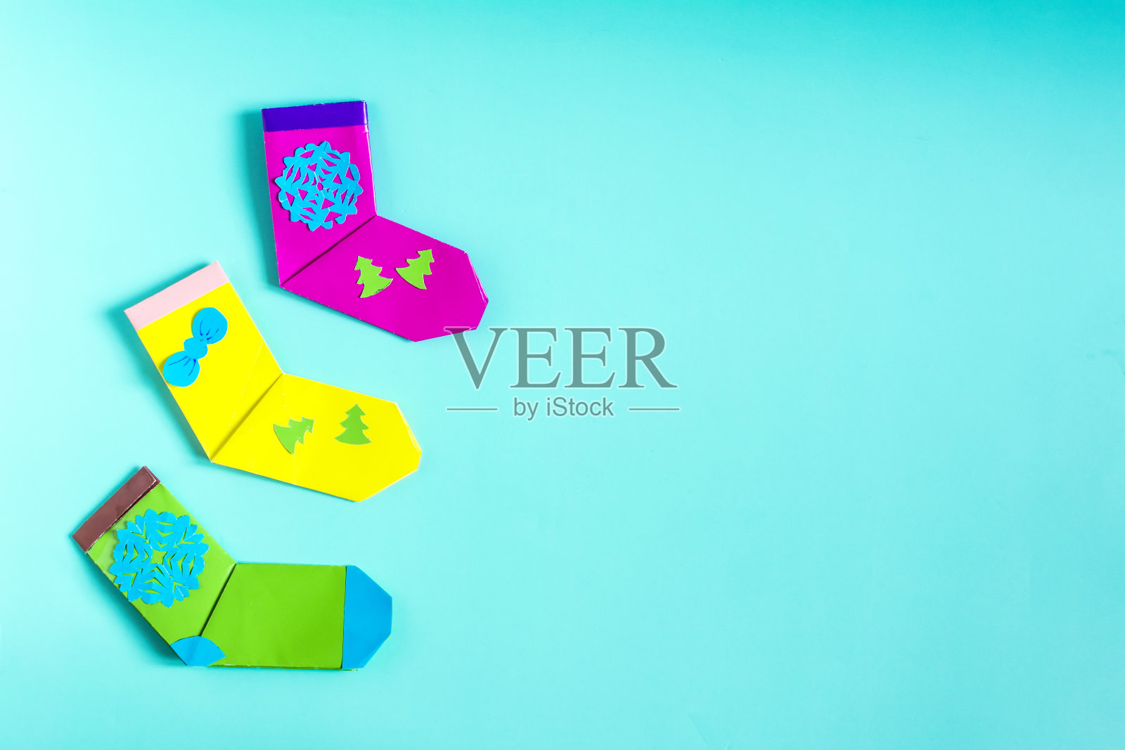 明亮的圣诞节装饰，色彩鲜艳的袜子纸上的彩色背景的地方的文字。照片摄影图片