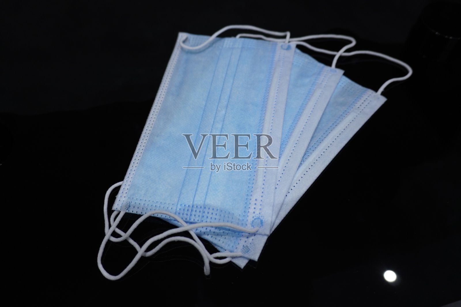 玻璃桌上放着一堆新的蓝色面具照片摄影图片