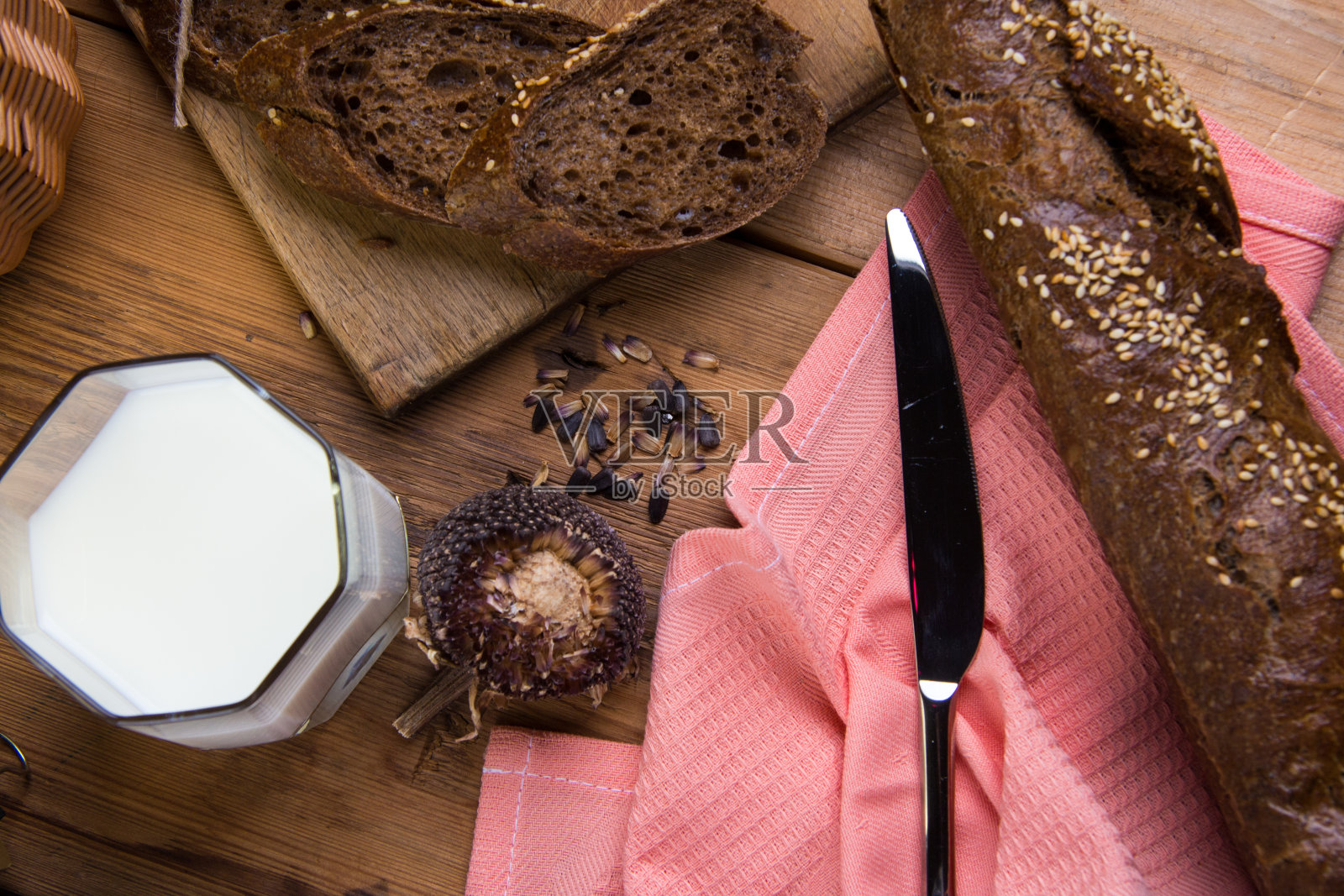 木板上的黑面包，一杯牛奶和葵花籽照片摄影图片