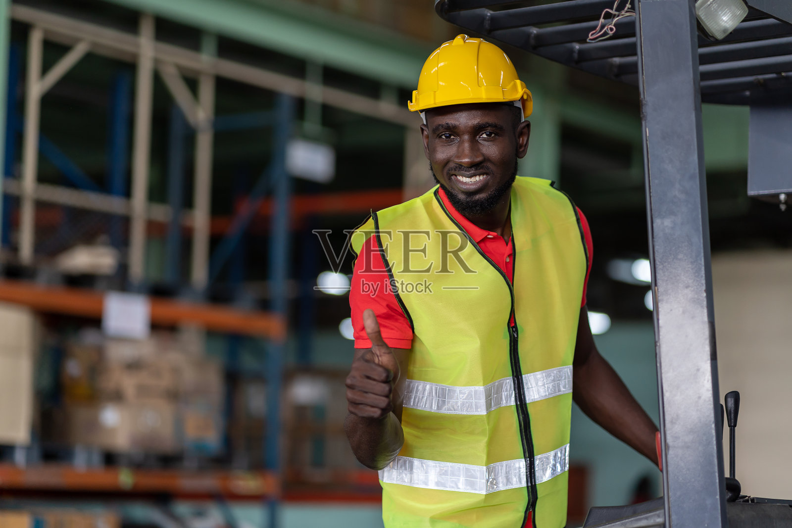 非裔美国男性工人，驾驶叉车在工业仓库中转产品或包裹货物。多元文化的工人照片摄影图片