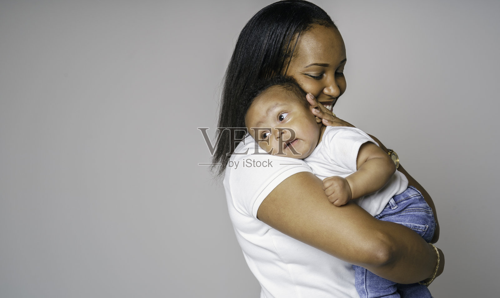 美丽的非洲妇女的肖像手拉着手她的小儿子在灰色的背景照片摄影图片