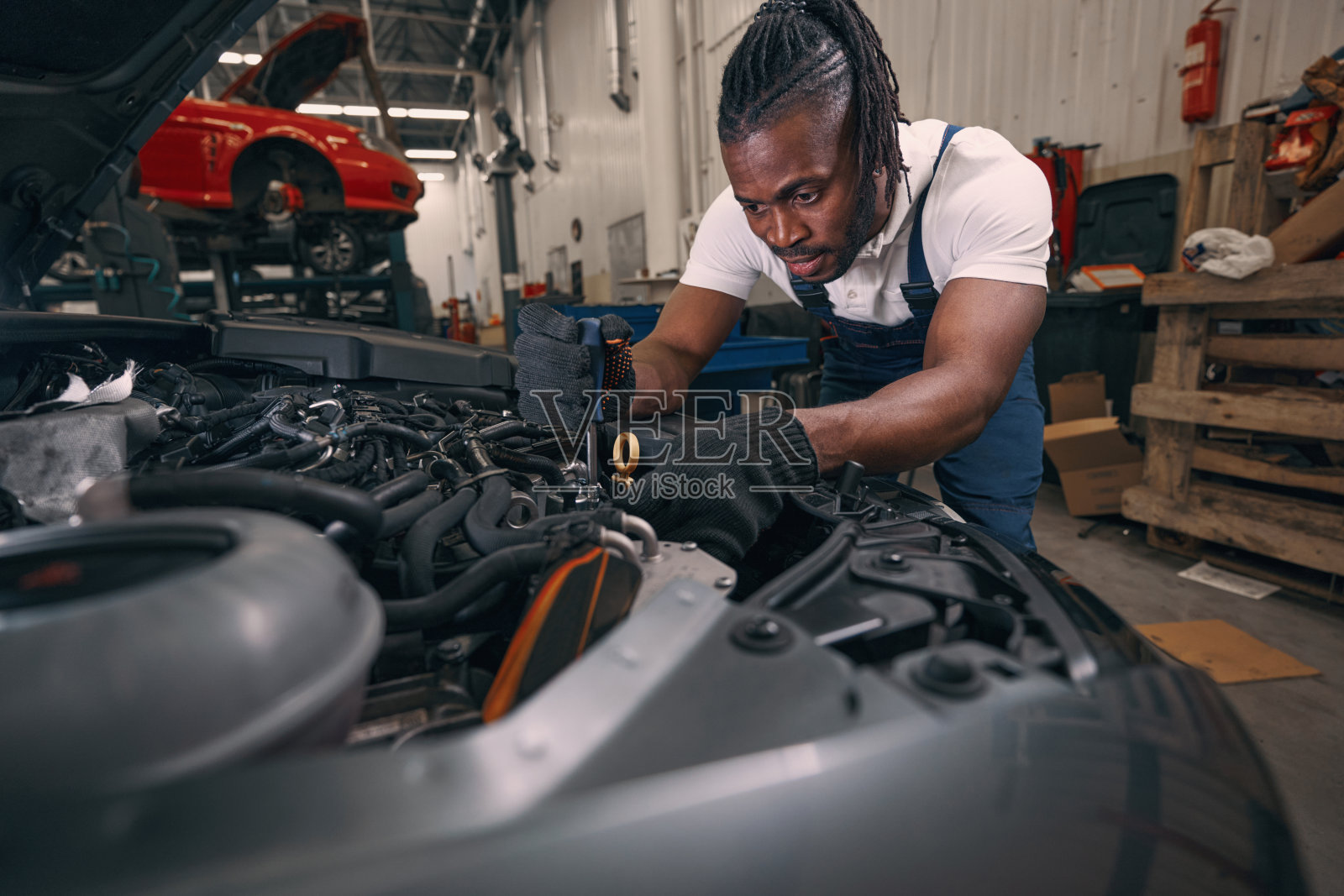 多民族修理工在发动机部件上使用螺丝刀照片摄影图片