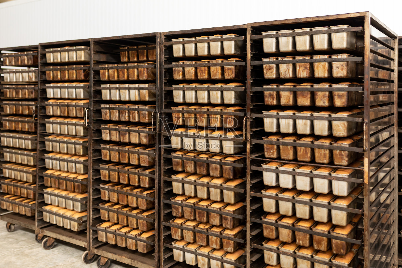 金属架子上放着新鲜出炉的小麦面包。照片摄影图片