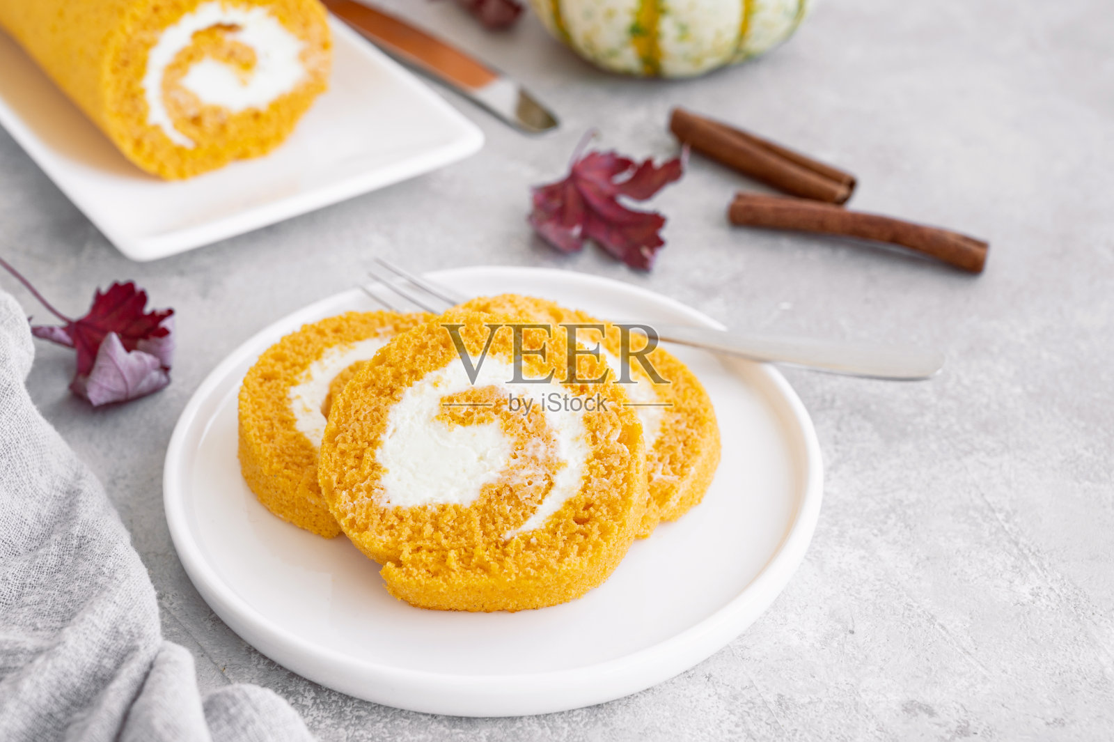 南瓜蛋糕卷，奶油芝士馅，灰色混凝土背景。感恩节或万圣节的甜点。选择性聚焦，复制空间。照片摄影图片