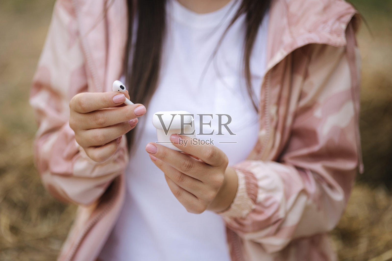 一名女子从充电器盒里拿走了无声耳机照片摄影图片