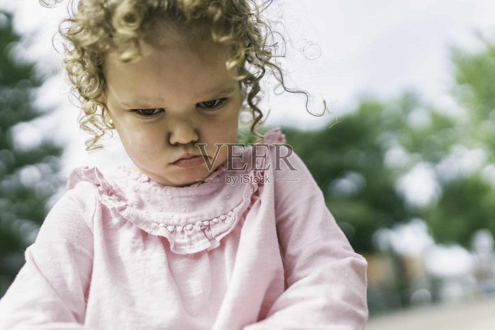 年轻女孩坐在学校操场的地板上照片摄影图片