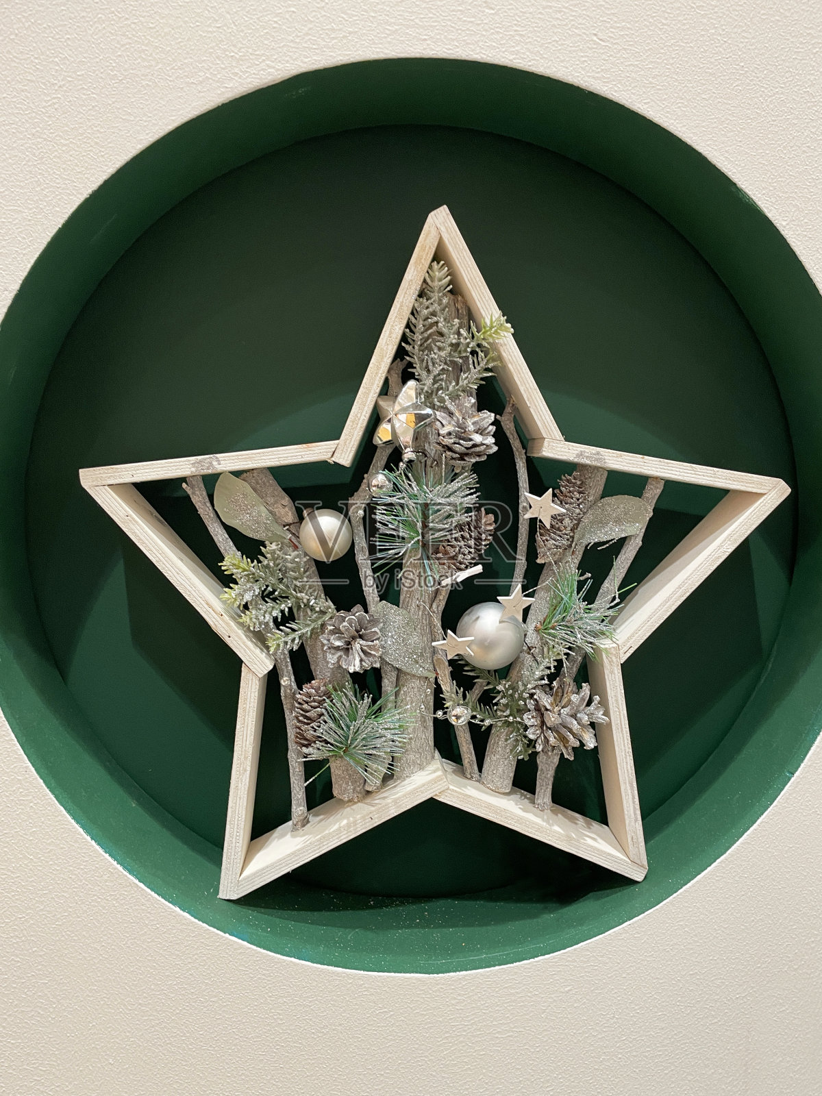 特写图像的单个木制星形圣诞装饰在绿色，圆形的洞，高架的观点照片摄影图片