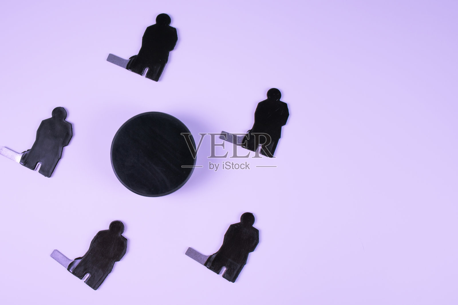 蓝色背景上的五个冰球运动员和一个冰球的剪影。照片摄影图片