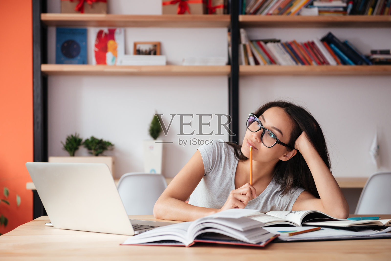 坐在室内用笔记本电脑看杂志的女人照片摄影图片