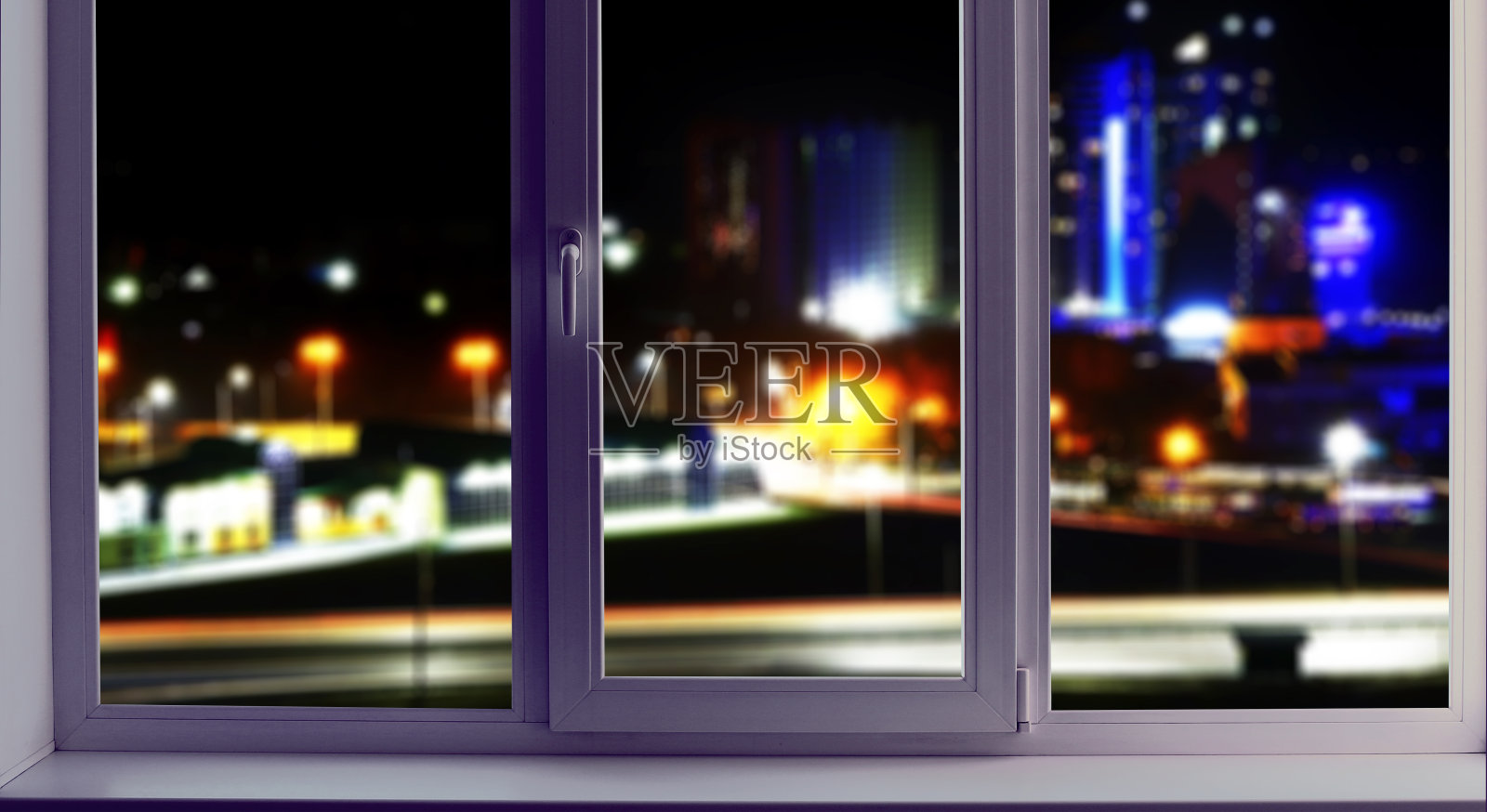 窗外的景色，模糊了夜城的背景。城市景观的软焦点。照片摄影图片
