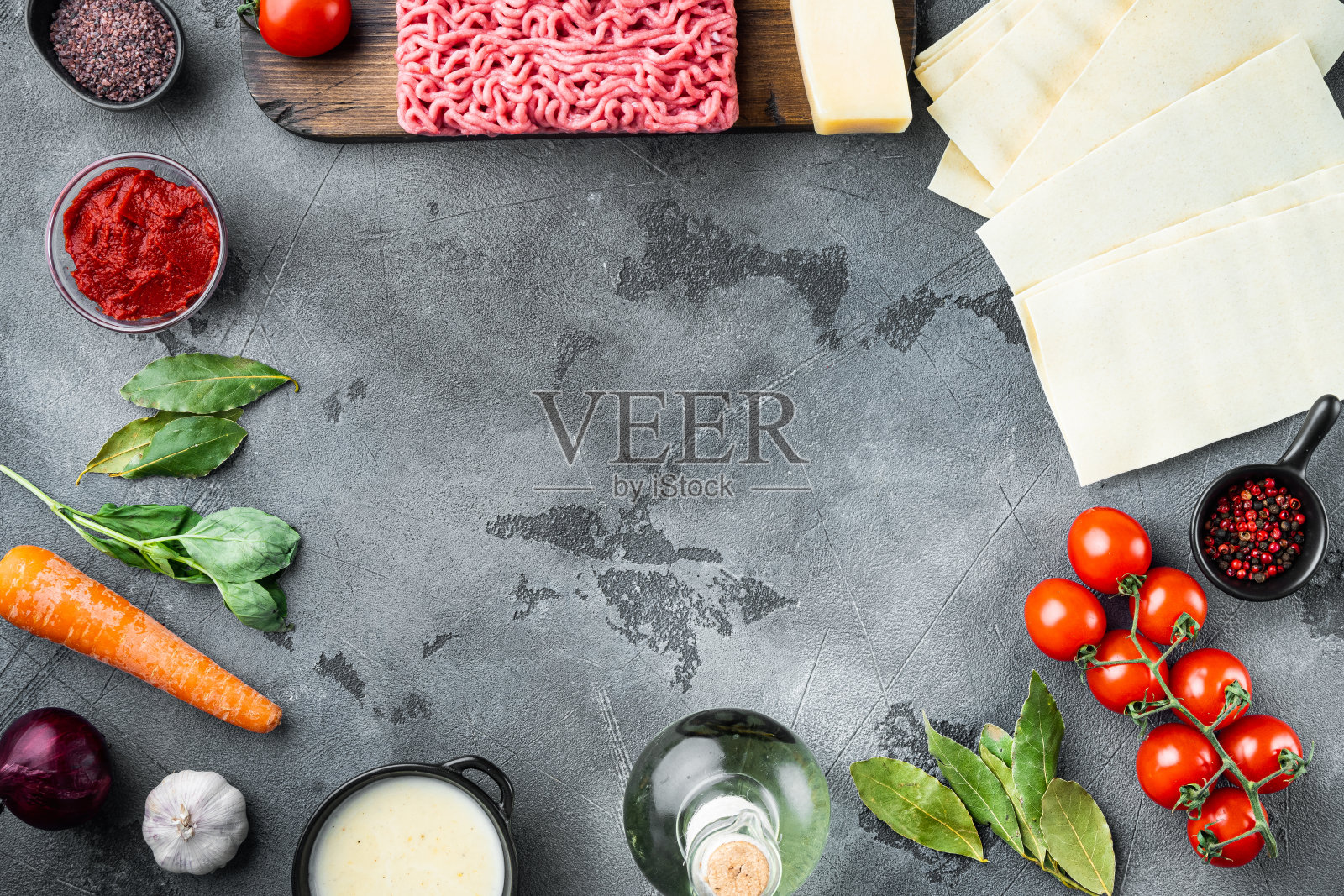 烹饪千层面的概念。意大利食材，宽面条片肉香草西红柿，白汁酱，灰色石头背景，俯视图，平躺，复制空间的文本照片摄影图片