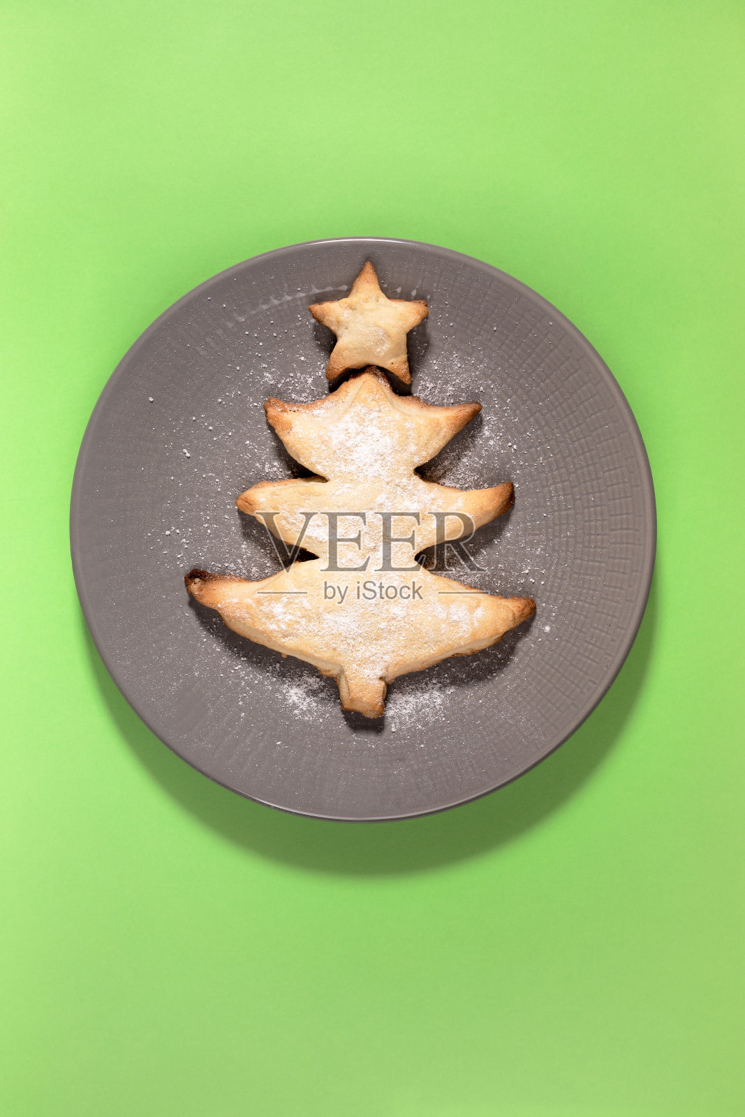 自制的创意烤饼干，就像圣诞树一样放在绿色的灰色圆盘子上。垂直方向。照片摄影图片