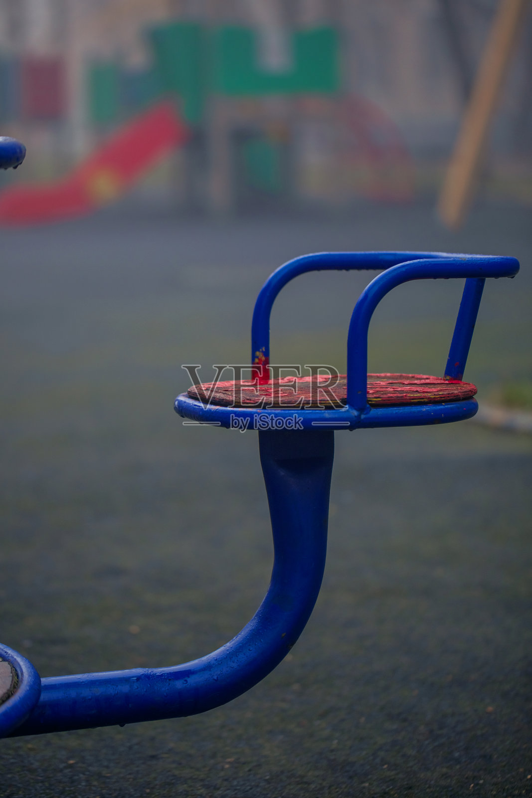 部分的蓝色和红色的铁秋千在操场上。旋转木马的座位。休息,童年。照片摄影图片