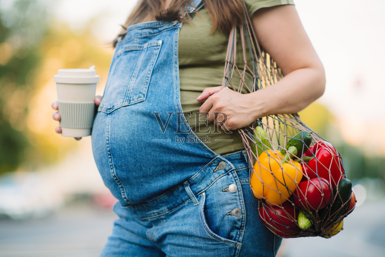 孕妇在夏天拿着环保袋在户外照片摄影图片