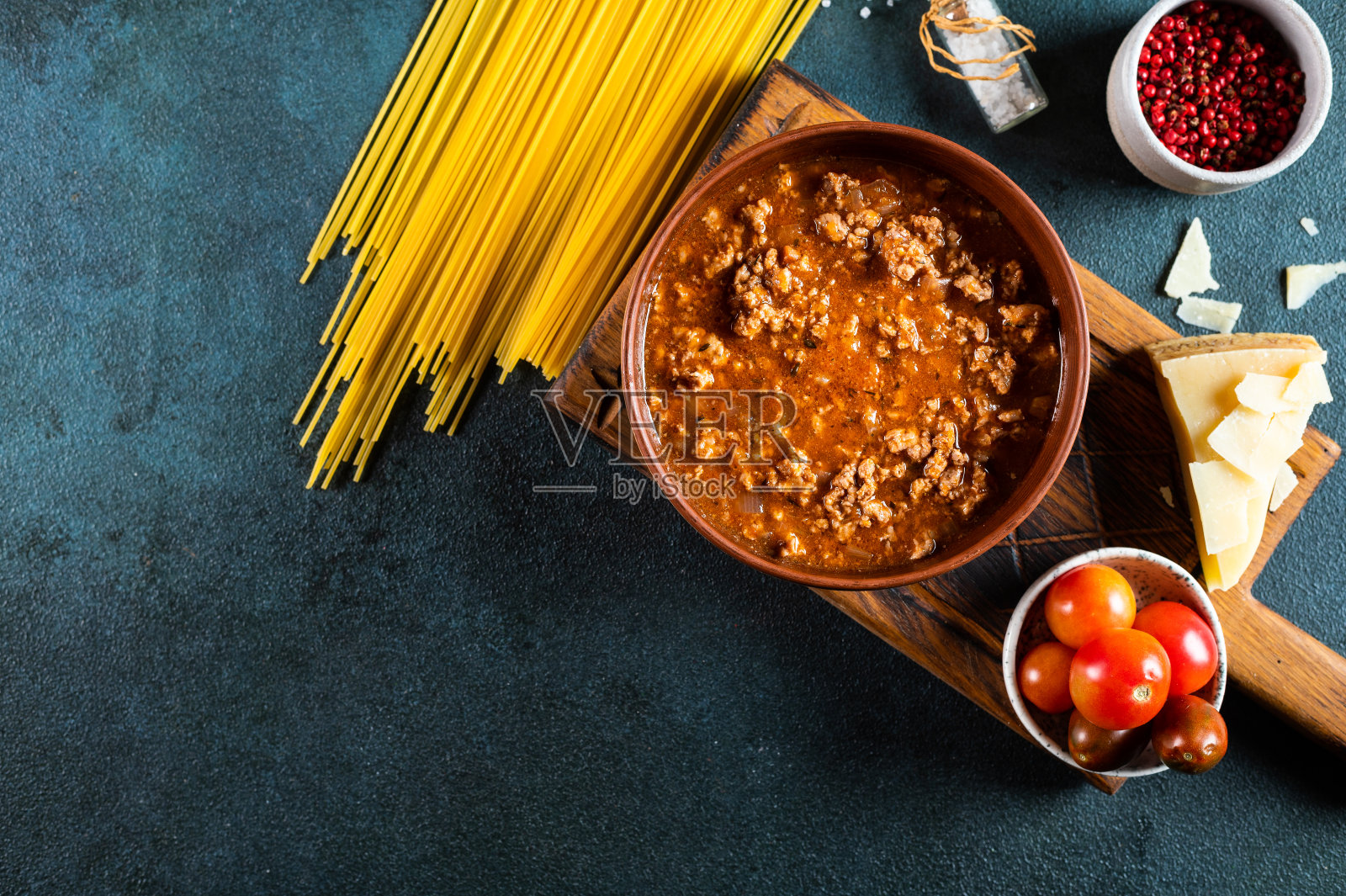 黑色背景下的意大利肉酱面配料。生面波伦亚人。面食flatlay。意大利波伦亚人。食品配料。意大利面俯视图照片摄影图片