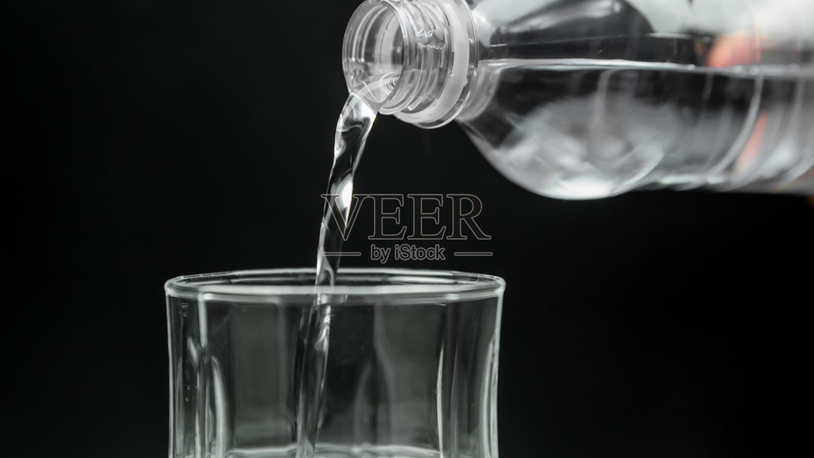 瓶装水倒进玻璃杯里照片摄影图片