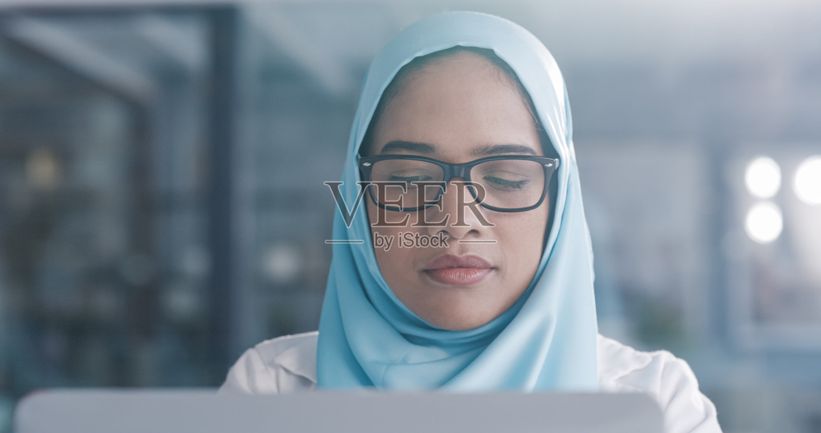 一名年轻女医生在办公室使用笔记本电脑照片摄影图片