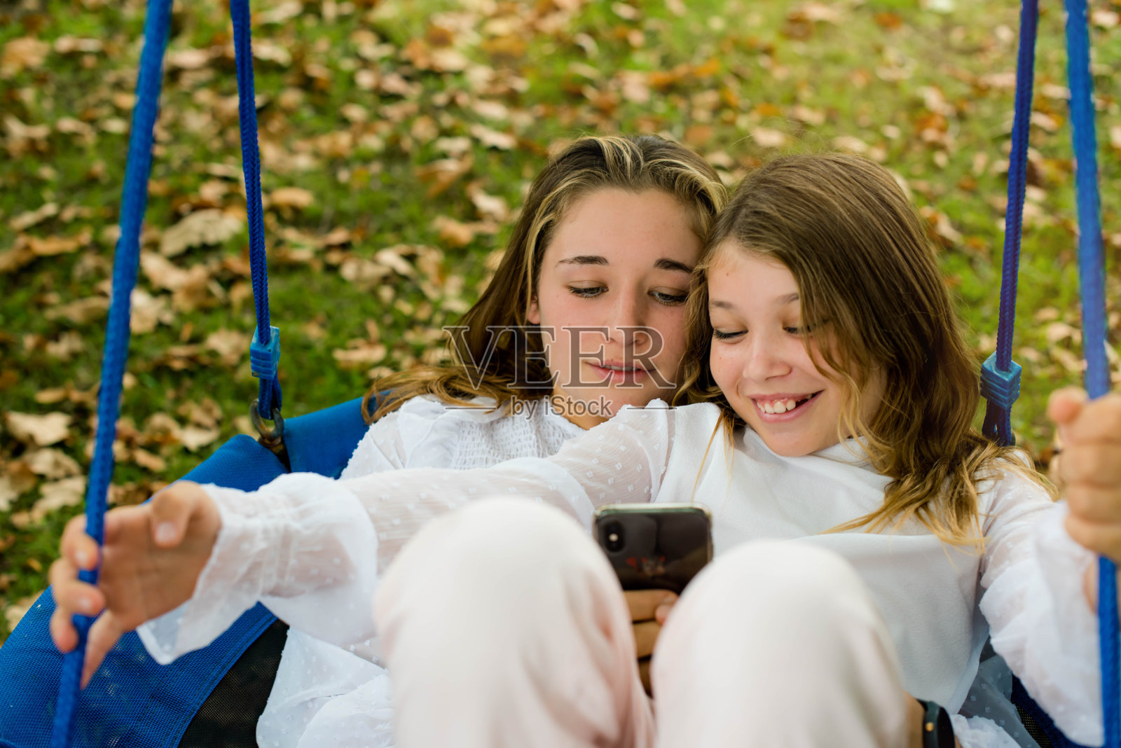 秋天，两姐妹在一起荡秋千照片摄影图片