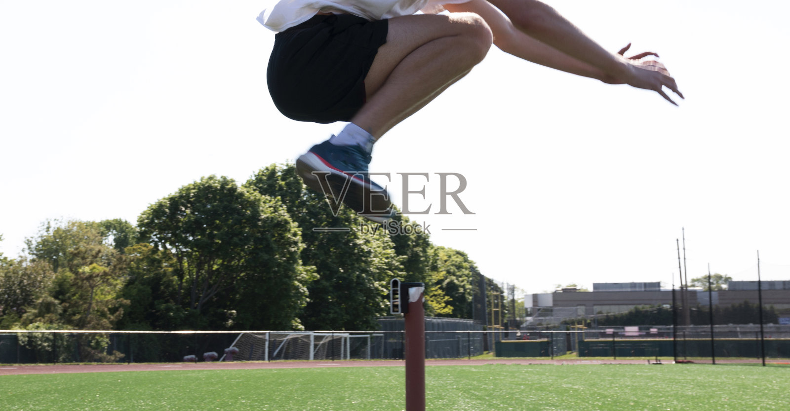 跳过跑道栏的运动员照片摄影图片