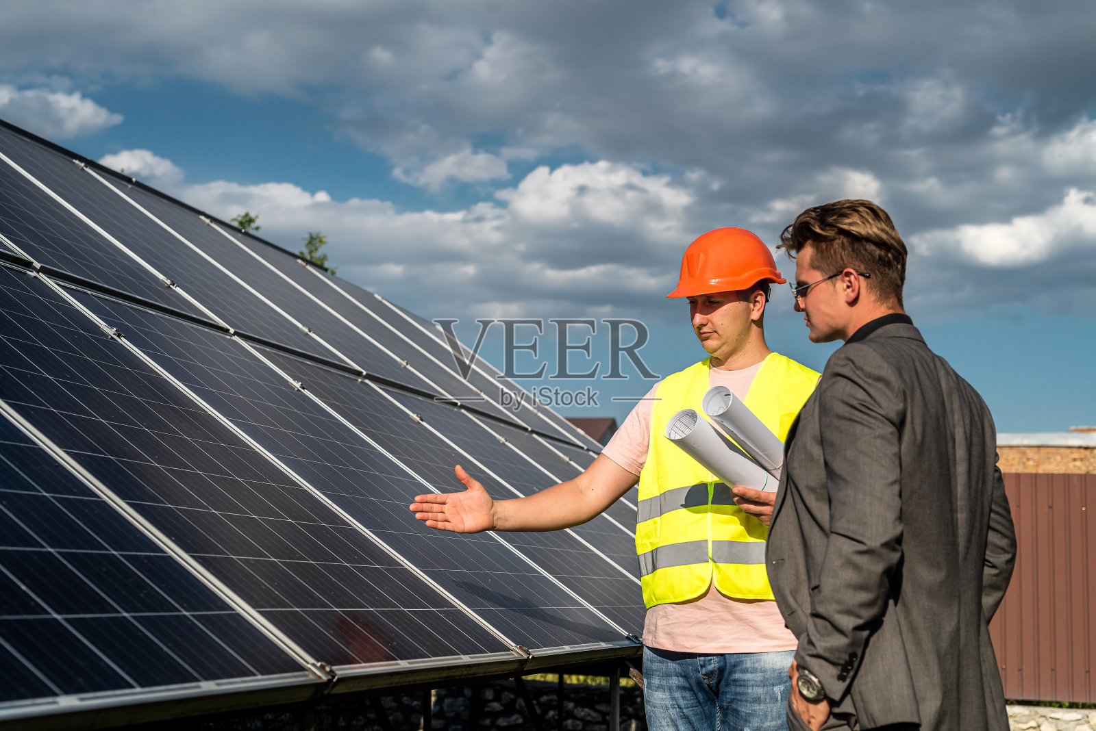 两个人在讨论新的太阳能电站的安装方案。绿色能源理念，可再生能源照片摄影图片