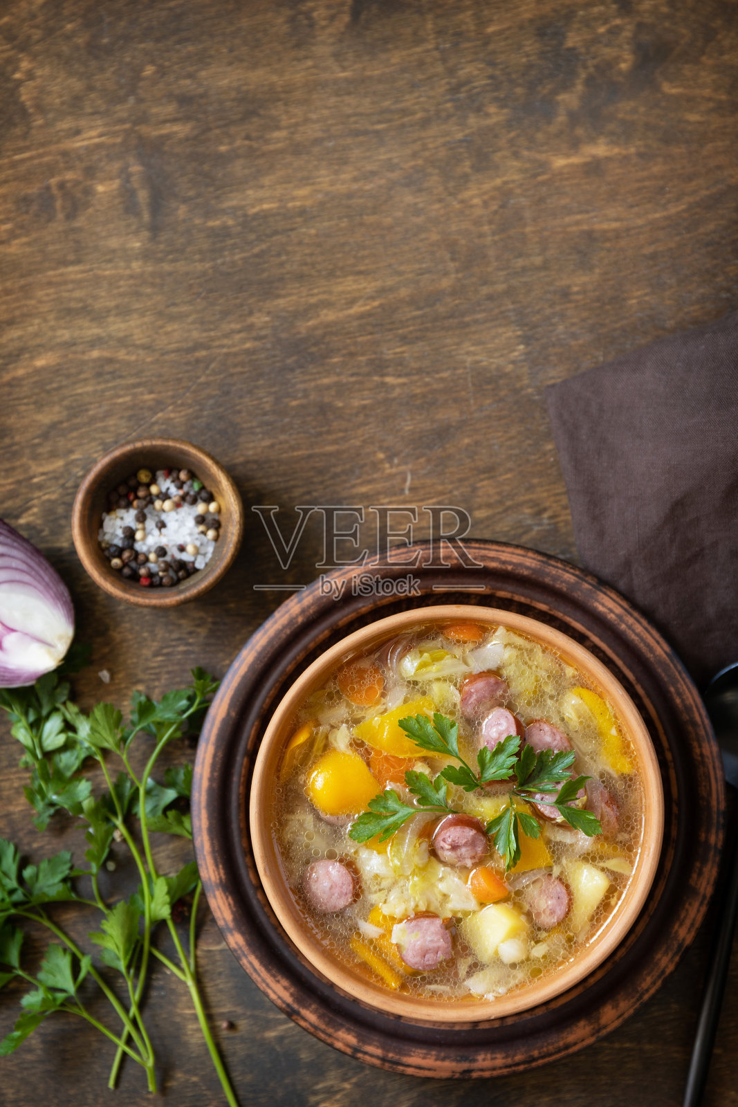 捷克食物:传统的泽尔纳卡卷心菜汤，香肠和蔬菜放在碗里，放在质朴的木桌上。俯视图平面背景。副本的空间。照片摄影图片