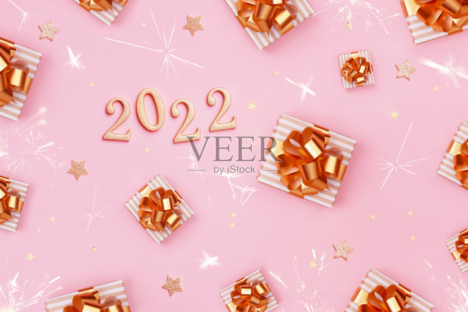 新年快乐的图案与礼物或礼物和2022数字在粉红色的桌子上。平的。照片摄影图片