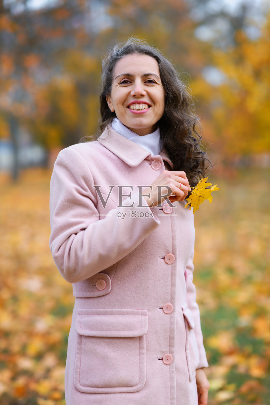秋天公园里一个女人的肖像。美丽的树，黄色的叶子。照片摄影图片