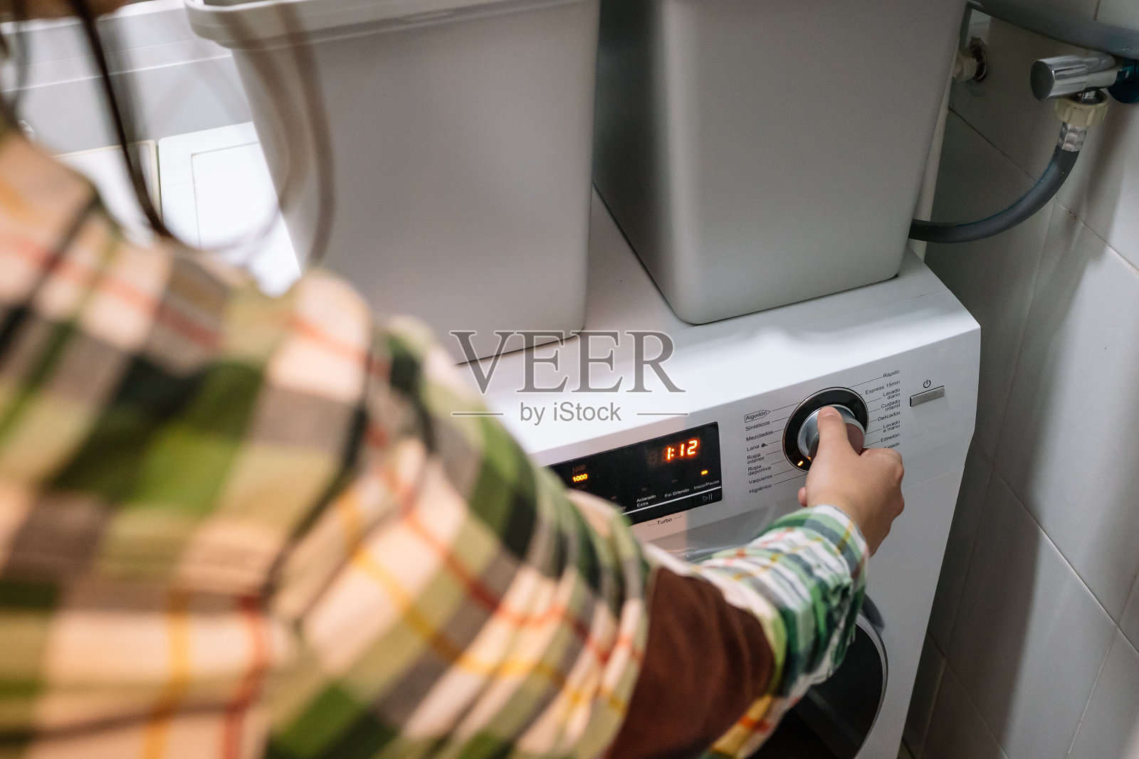 由于电费上涨，一名年轻女子在半夜打开洗衣机照片摄影图片