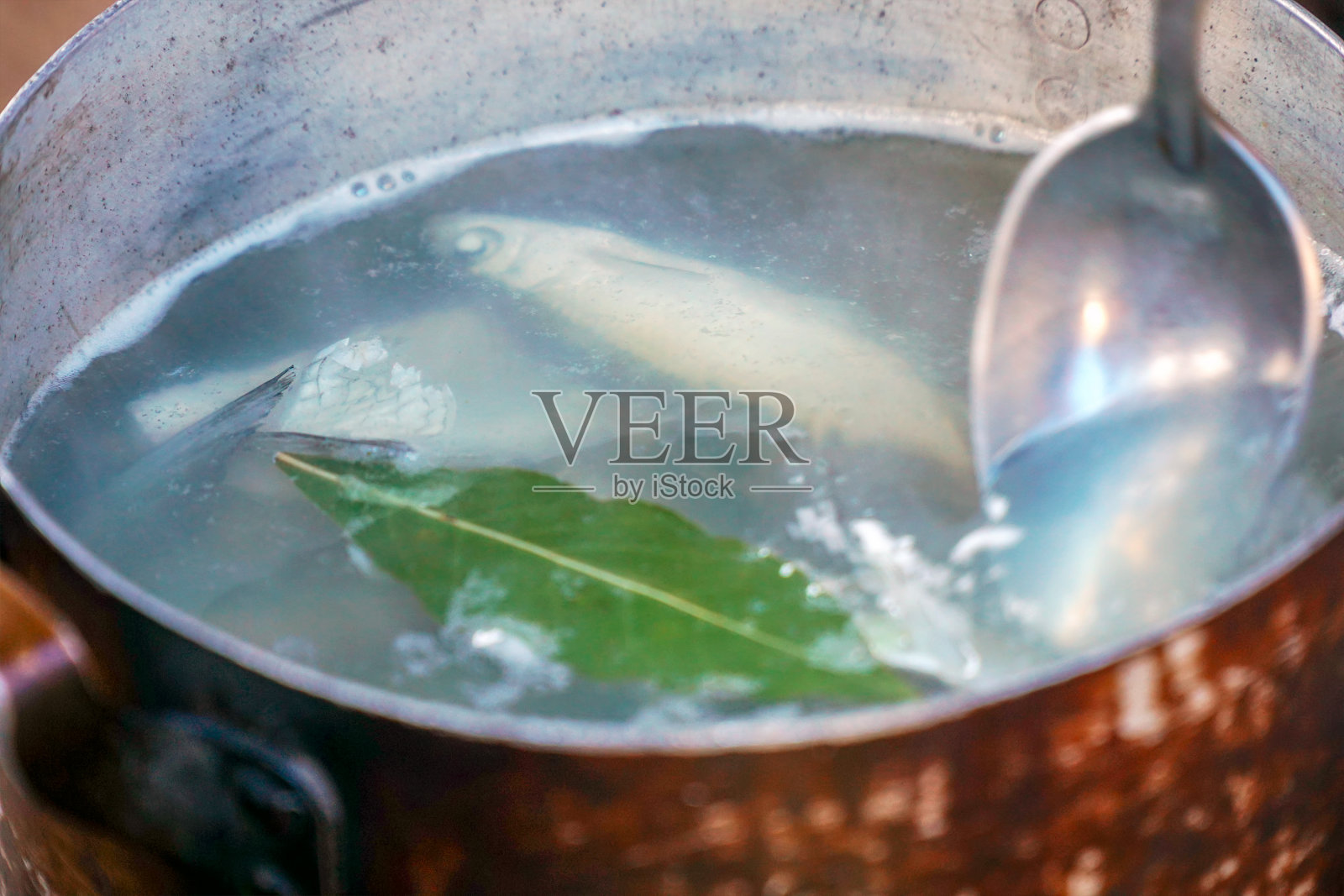 在大自然中煮鱼汤或钓鱼。平底锅里的鱼汤正在沸腾照片摄影图片