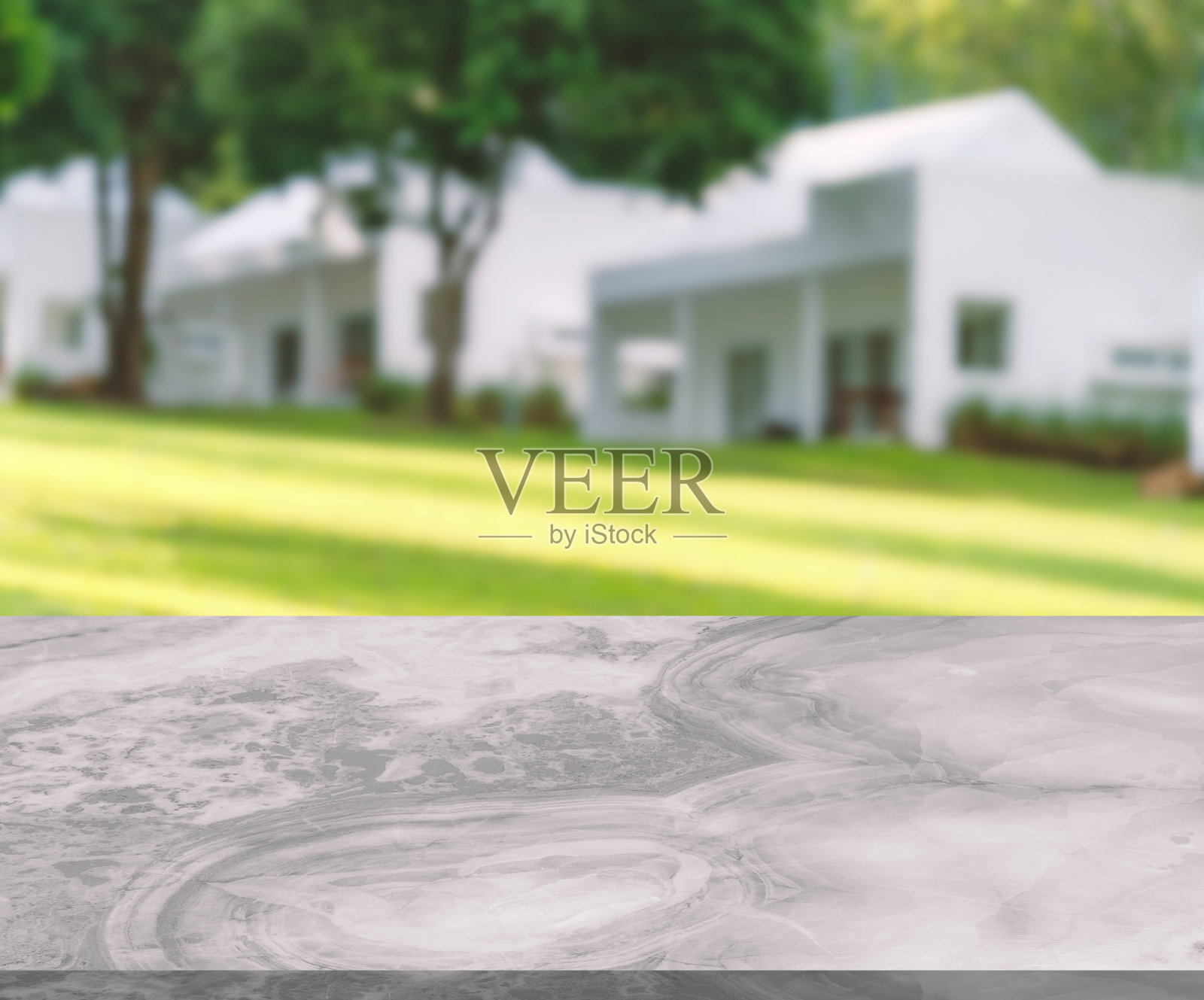 用于产品展示的大理石桌子的空白空间，小而有光泽的表面，以度假村山坡上模糊的白色房屋为背景的透视视图。照片摄影图片