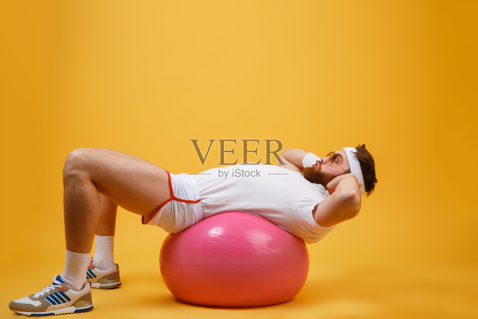 运动员躺在健身球上的侧面照片摄影图片