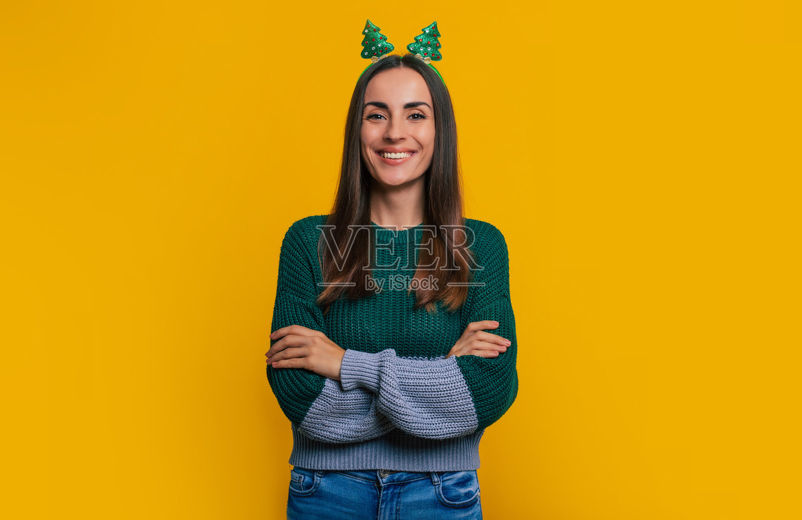 可爱的快乐时尚的女人穿着休闲的圣诞服装，在黄色的背景上微笑着摆出孤立的姿势照片摄影图片