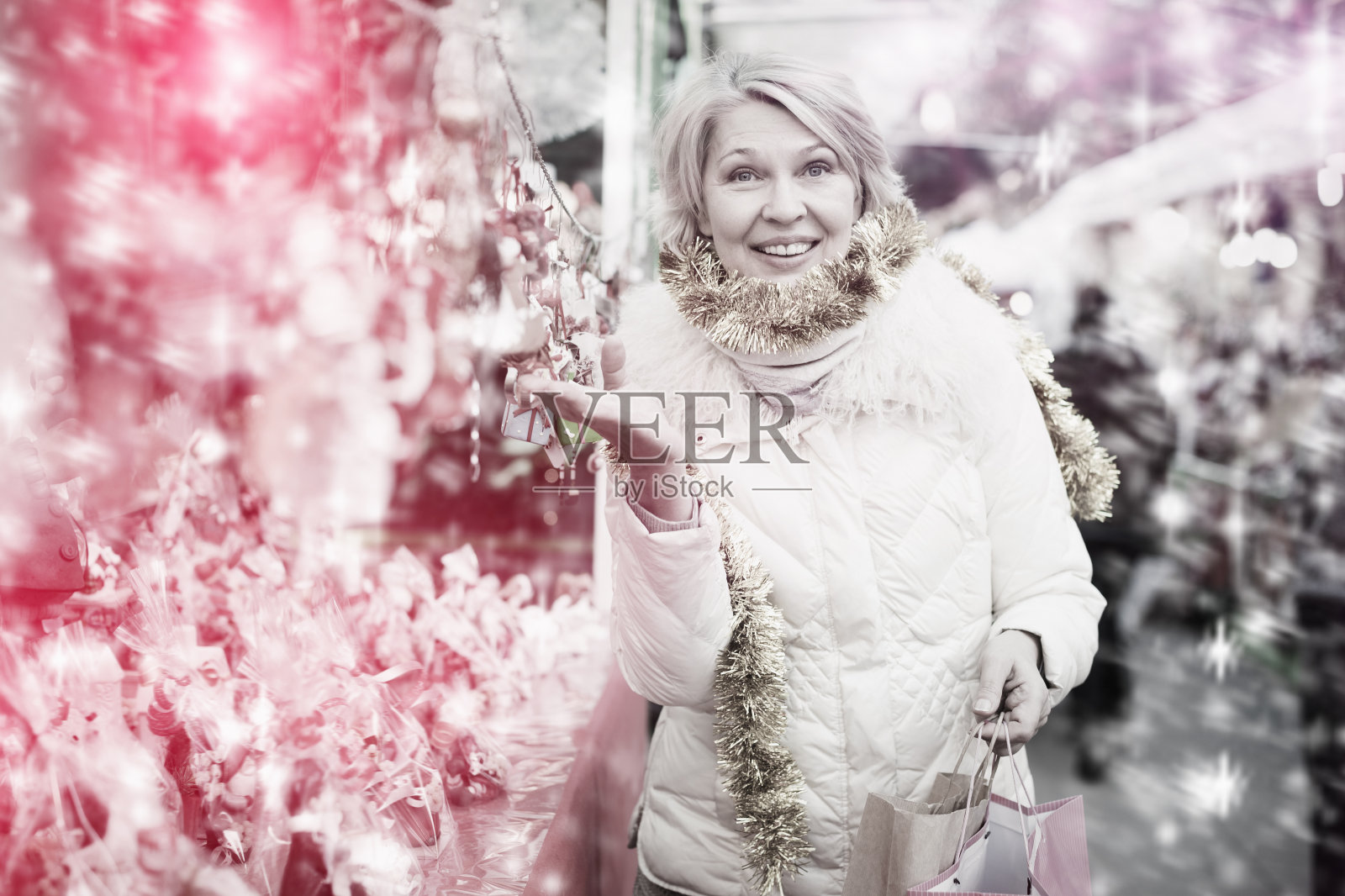 积极成熟女性在圣诞集市购买装饰品照片摄影图片