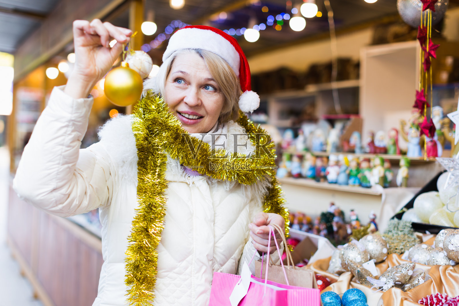 戴着圣诞帽的妇女在市场挑选装饰品照片摄影图片
