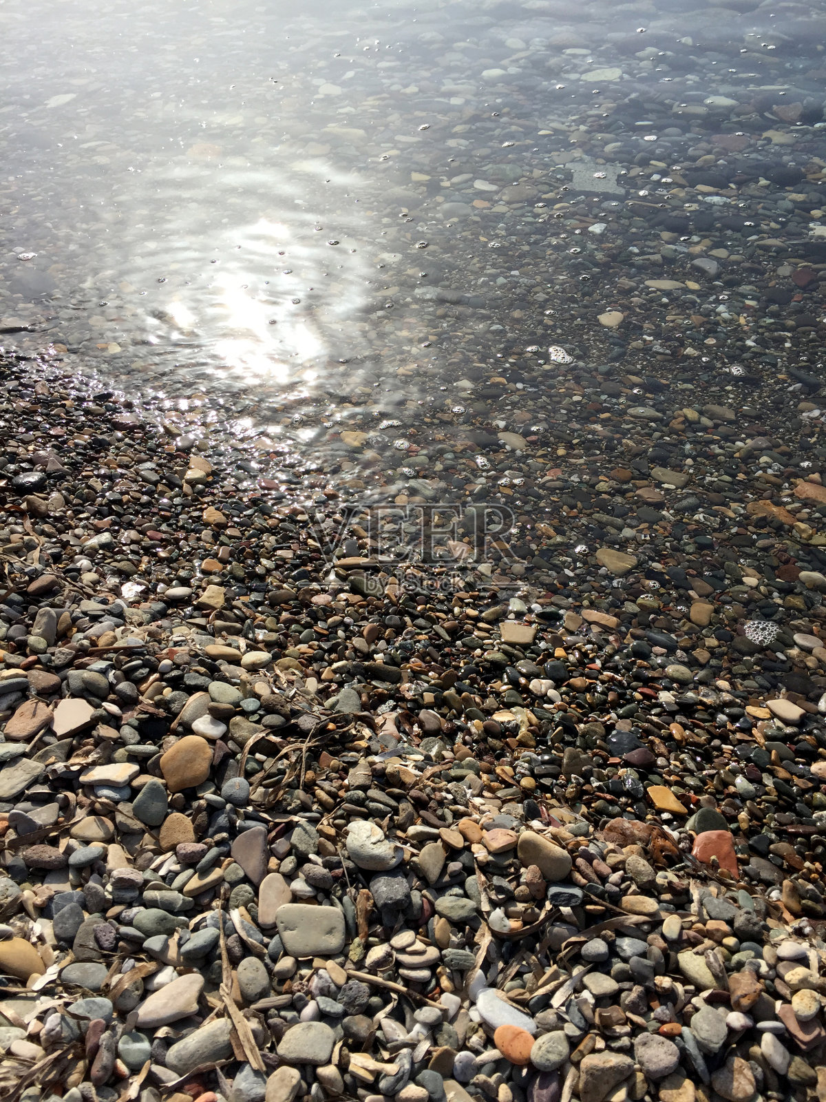 海边的卵石反射着阳光照片摄影图片